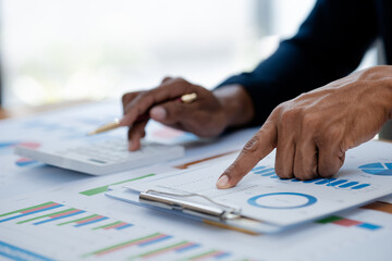 Business man pointing to a pie chart document showing company financial information, He sits in her private office, a document showing company financial information in chart form. Financial concepts