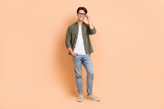 Full body length size cadre of young optimistic man wear stylish outfit casual style new eyeglasses advertisement isolated on beige color background