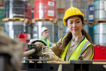 woman engineer wear hard hat working at machine in factory. female technician control metalwork lathe industrial. female workshop technology manufacturing.