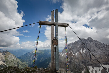 Between Italy and Austria: Cross on the top of mountain near Volaia Lake Raunchkofer Mountain (Lago di Volaia Monte) with sign in german "Europe Berge verbinden" - "Europe connecting mountains".