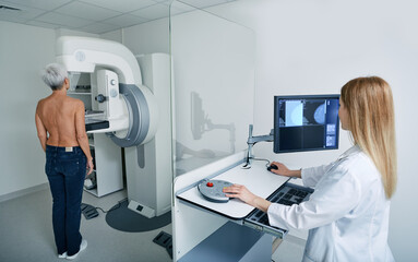 Mammogram procedure. Preventive diagnostic of senior woman by radiologist using mammography...