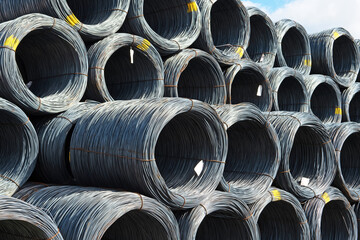 Rolls or bales of wire are stacked on top of each other.
