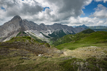 Between Italy and Austria: mountain hiking Trail Road near Volaia Lake Raunchkofer Mountain (Lago di Volaia Monte). Grey sky before thunderstorm background.