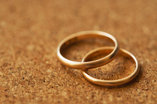 Two wedding rings on a cork table background with shallow DOF