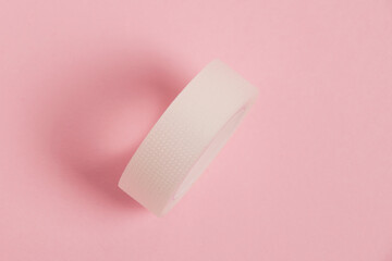 Flatlay, medical transparent plaster for applying bandages on a pink background