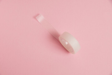 Flatlay, medical transparent plaster for applying bandages on a pink background