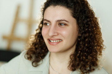 Portrait of a young, curly mixed race student or businesswoman in room in a library or office