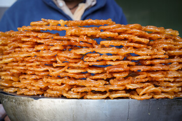 Making or cooking of Jalebi is a sweet Indian sweetie with syrup fried out in oil. Many Indian jalebis arranged for sale. Street food for Diwali in Kullu Manali Himachal Pradesh India.	