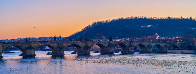Panorama of medieval arched Charles Bridge across Vltava River and Mala Strana neighborhood of Prague, Czechia