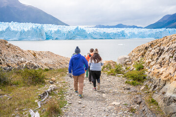 Un grupo de personas se están dirigiendo hacia el glaciar Perito Moreno para realizar el mini trekking.
 - obrazy, fototapety, plakaty