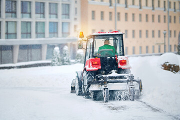 Tractor sweep snow, plow snow with rotating brush and snowplow from sidewalk. Snow plow vehicle...