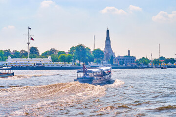 Fast passenger boat sails across Chao Phraya river to Wat Arun temple, Bangkok, Thailand
