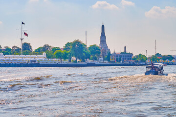Passenger boat on Chao Phraya river and Wat Arun temple on background, Bangkok, Thailand