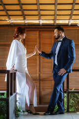 bride in a white dress with a bouquet and the groom in a blue suit