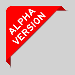 Red color of corner label banner with word alpha version on gray background
