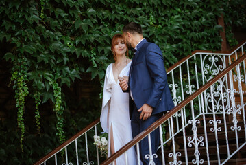 bride in a white dress with a bouquet and the groom in a blue suit