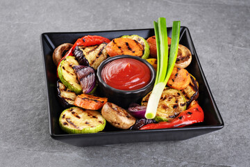 Grilled vegetables eggplants aubergine, carrots, zucchini, champignons, bell pepper, onion on a plate.
