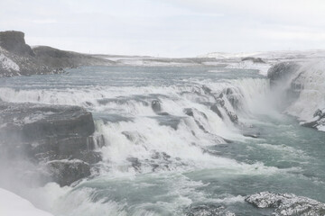 Winter landscape of a waterfall in Iceland. The area is covered with snow.