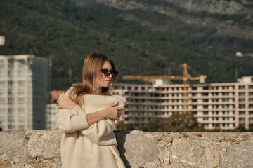 Fototapeta premium The girl crossed her arms over her chest, holds on to her shoulders and looks to the right