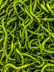 Green, young beans or peas close-up on the store counter, top view.  A large amount of fresh green beans, top view, close-up. Natural vegetables for vegetarians. Vertical photo. 