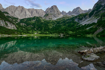 Fototapeta na wymiar famous Seebensee in the austrian Alps at Coburger Hütte with jagged majestic mountain renge in the background reflecting in the mountain lake