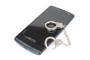 Old used smartphone with handcuffs on white background.