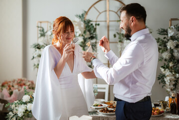 newlyweds happily cut and taste the wedding cake