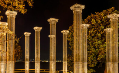 picturesque luminous transpatent columns in park with a night sky background, architecture constructions in ancient roman style