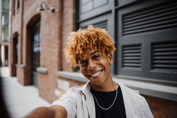 POV Multiracial man smiling confident while making selfie by the camera at the street