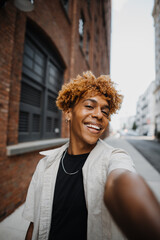 POV Vertical photo of multiracial guy smiling while making selfie by the camera