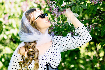 Portrait of a smiling young girl in blooming lilac trees. Summer time,vacation