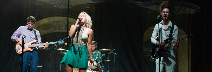 A rock band playing on the concert stage at summer night