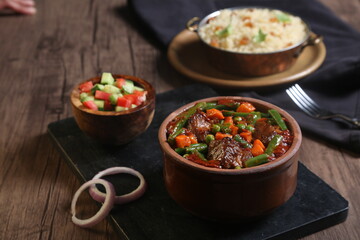 vegetable casserole with meat served with fresh salad on a black tray
