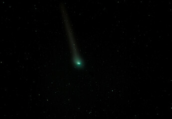 A green comet streaking across the night sky