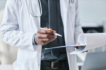 Close up African American doctor holding clipboard