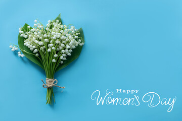 happy women's day greeting card with white lilies of the valley on a blue background, a bouquet of spring flowers, free space