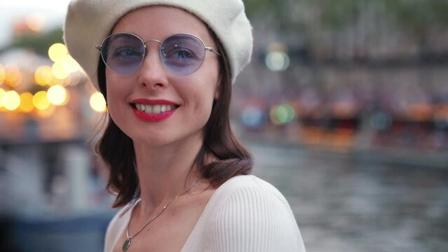 Portrait of a beautiful girl in a white beret on the background of a European city