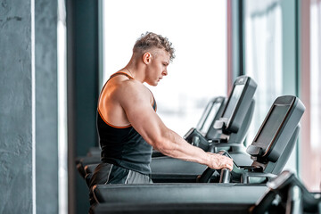 Naklejka na ściany i meble athlete on a treadmill in the gym