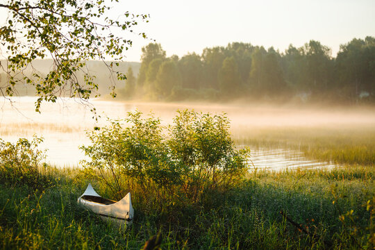 Fog over lake at sunrise in summer
