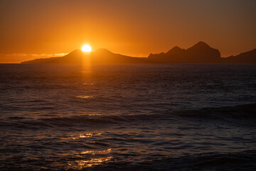 Fototapeta na wymiar Sunrise over Stormy Sea, Shining Golden Waves with Sun Reflection, Amazing light over Iceland Nature