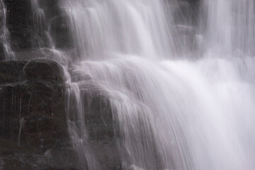 Naklejka na ściany i meble Long exposure of water flowing in a waterfall