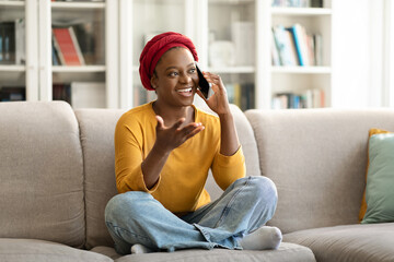 Obraz premium Relaxed candid young african american woman talking on phone