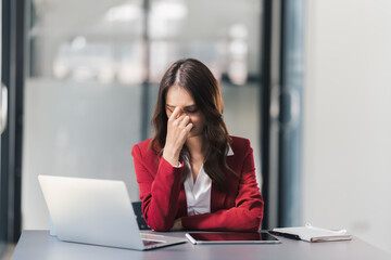 Obraz premium Stressed businesswoman overworked. Tired lady having headache sitting indoors..