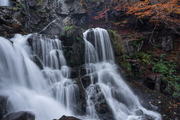 Long exposure of a waterfall in the forest in autum