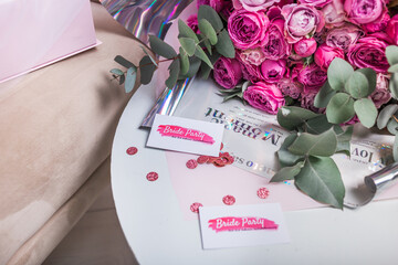 Invitations for a bachelorette party on the background of a bouquet of roses.