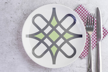 A Plate with the Flag of Hausa, Cutlery and Napkins on the Mable Table.