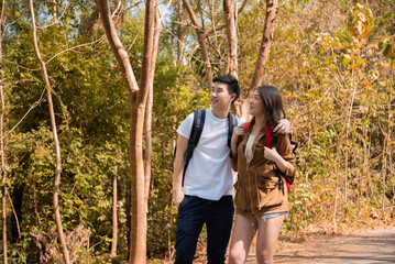 Young Asian couples have fun together in park, tourist outdoor adventure trip lifestyle spend time together trekking in forest during vacation or holiday, Adorable girl have happy time with boyfriend