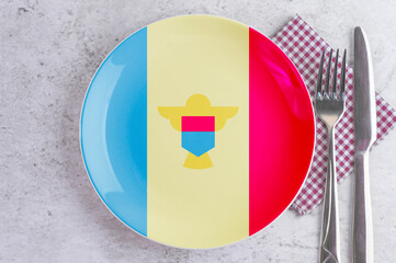 A Plate with the Flag of Moldova, Cutlery and Napkins on the Mable Table.