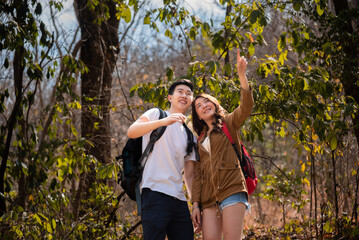 Young Asian couples have fun together in park, tourist outdoor adventure trip lifestyle spend time together trekking in forest during vacation or holiday, Adorable girl have happy time with boyfriend