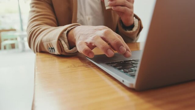 Close-up of young businessman's hands working on laptop